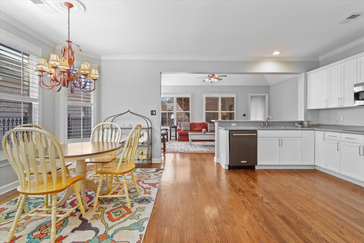 1495 Kimbrough Road Germantown, TN 38138 - Photo 10 of 31 Dining area with ornamental molding, ceiling fan with notable chandelier, baseboards, light wood finished floors, and visible vents