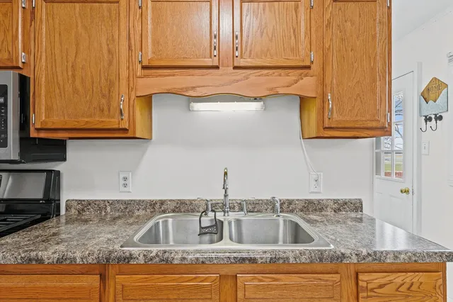 a kitchen with granite countertop wooden cabinets and a sink