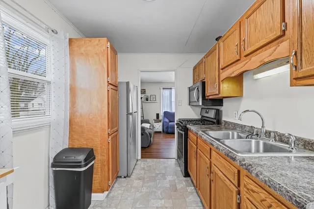 a kitchen with stainless steel appliances granite countertop a sink stove and refrigerator