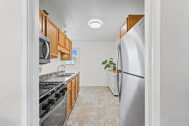 a kitchen with stainless steel appliances granite countertop a refrigerator and a stove