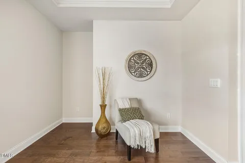 a view of a hallway with wooden floor and a bathroom