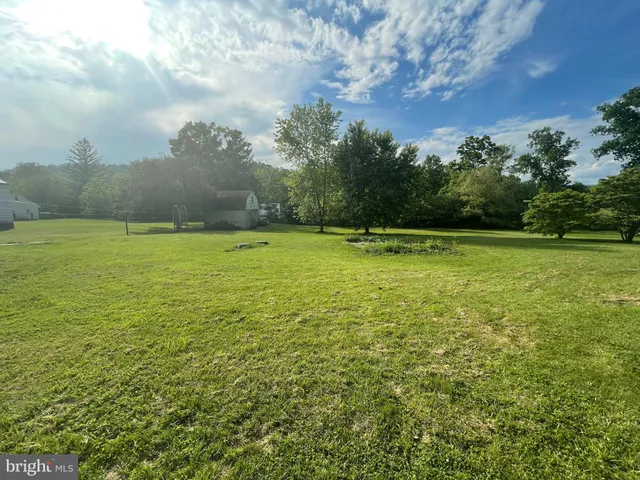 a view of a field with an trees in the background