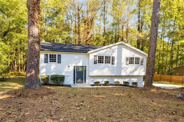 a view of a house with backyard and a tree