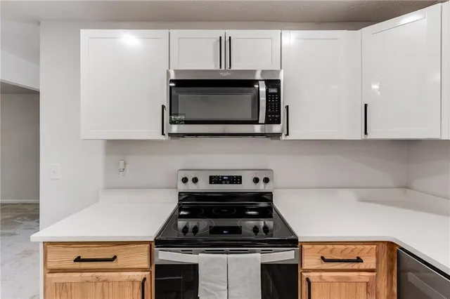 a kitchen with stainless steel appliances a stove a microwave and cabinets