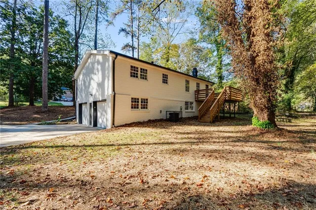 a view of a truck parked in a yard with large trees