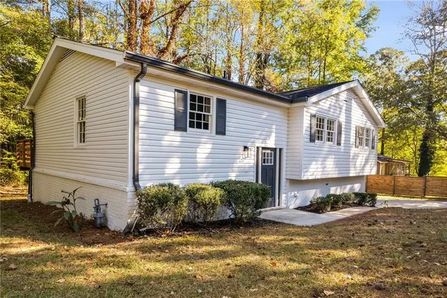 a view of a house with a yard and large tree and plants