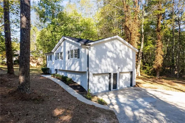 a view of a wooden house with large trees