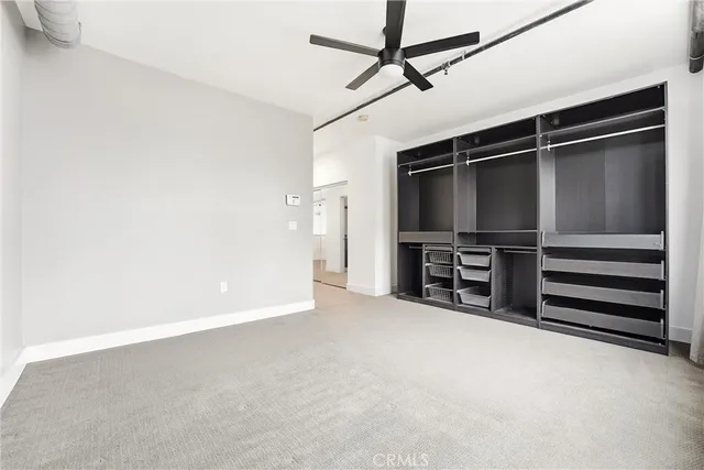 an empty room with a ceiling fan and window