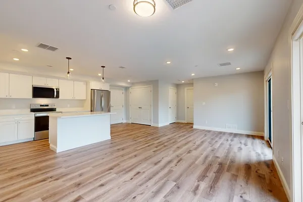 a view of kitchen with wooden floor and electronic appliances