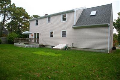 32 Meadowbrook Road Mashpee, MA 02649 - Photo 15 of 16 a backyard of a house with table and chairs