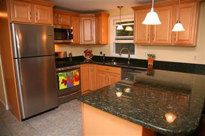 32 Meadowbrook Road Mashpee, MA 02649 - Photo 5 of 16 a kitchen with stainless steel appliances granite countertop a sink a stove and a refrigerator