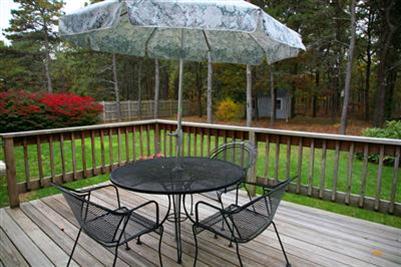 32 Meadowbrook Road Mashpee, MA 02649 - Photo 7 of 16 a view of a chair and table on the wooden deck