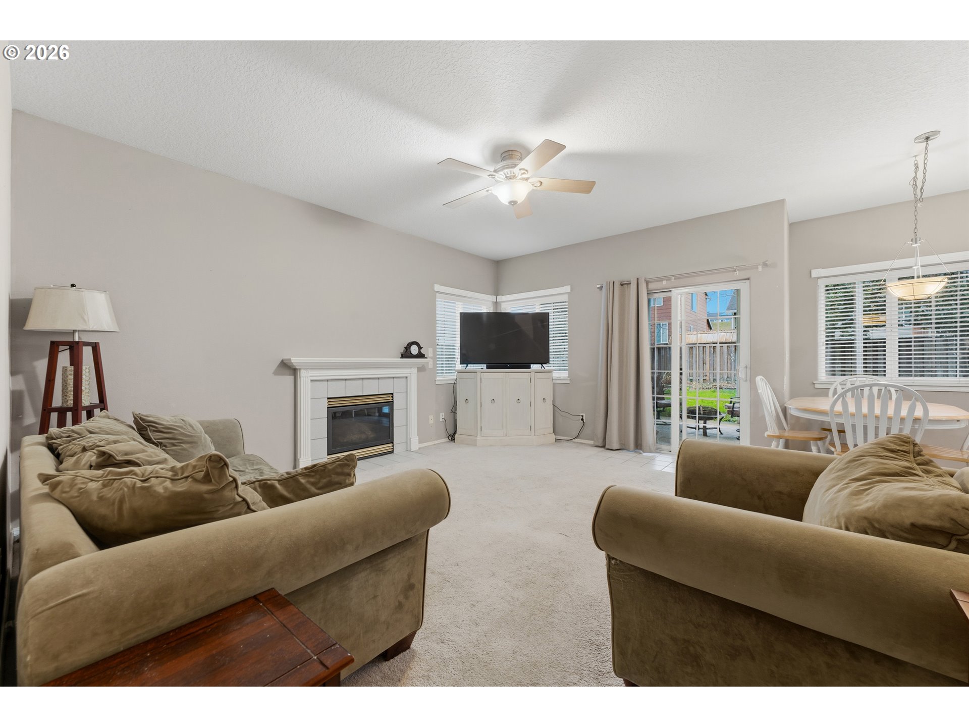 15852 Southeast Upman Way Damascus, OR 97089 - Photo 11 of 43 a living room with furniture a flat screen tv and a fireplace
