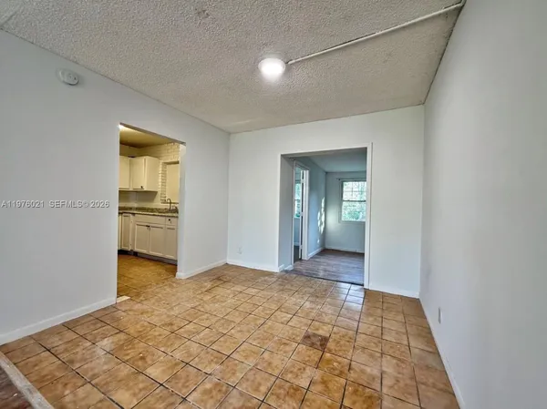 a view of a hallway with wooden cabinet and kitchen