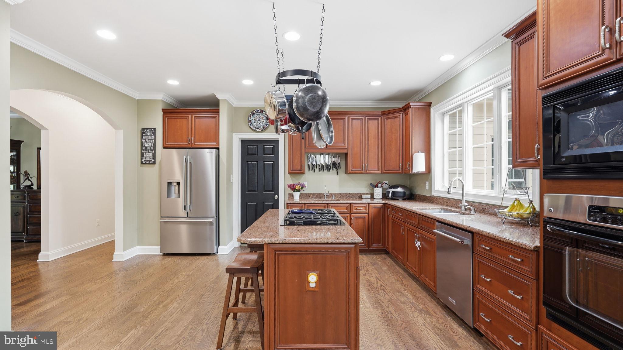 15613 Thoroughfare Road Gainesville, VA 20155 - Photo 11 of 63 a kitchen with stainless steel appliances granite countertop a stove refrigerator a sink dishwasher and wooden cabinets with wooden floor