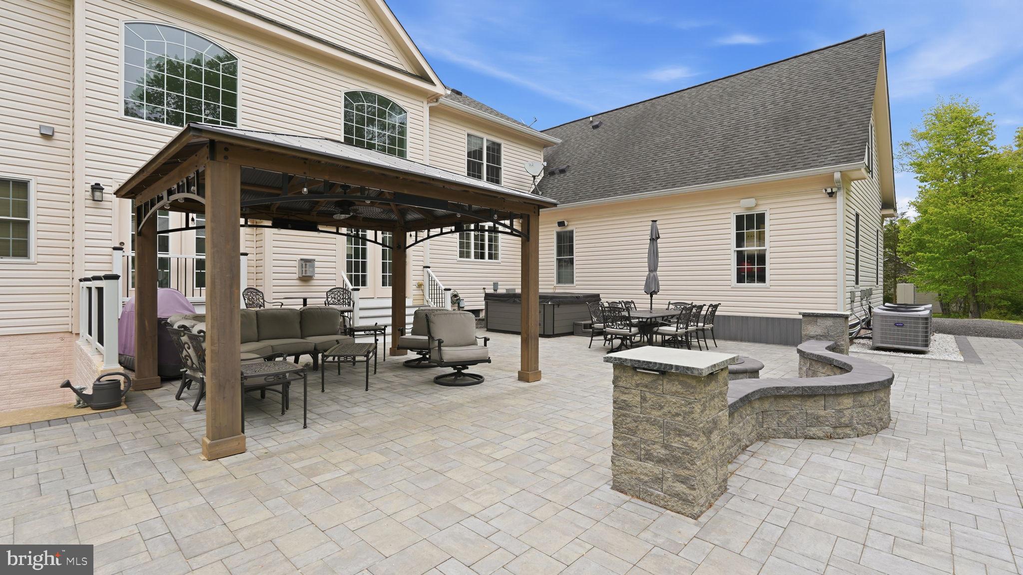 15613 Thoroughfare Road Gainesville, VA 20155 - Photo 54 of 63 a view of a patio with dining table and chairs under an umbrella