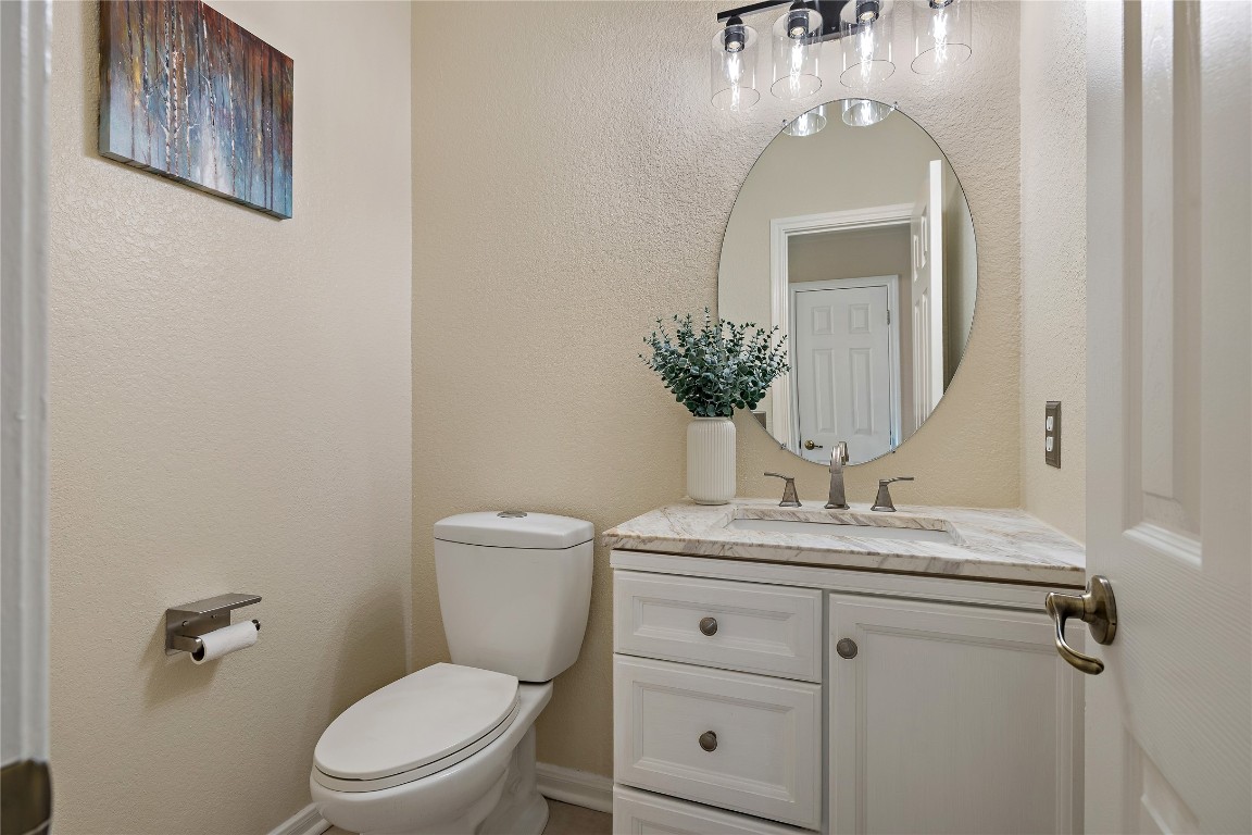 7002 Rambollet Terrace Round Rock, TX 78681 - Photo 18 of 37 a bathroom with a granite countertop toilet sink and mirror