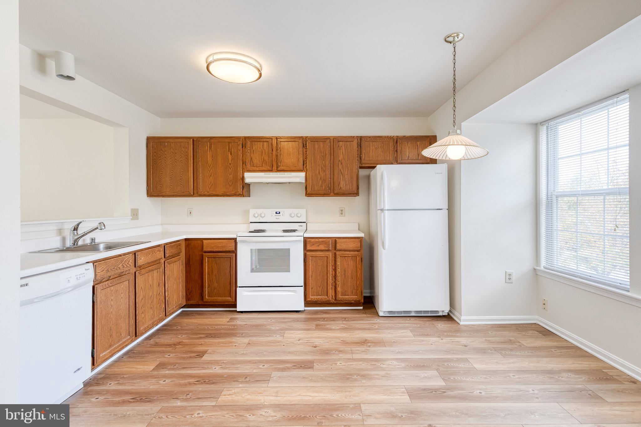 611 Brickston Road Reisterstown, MD 21136 - Photo 7 of 16 a kitchen with a sink a stove a refrigerator and white cabinets