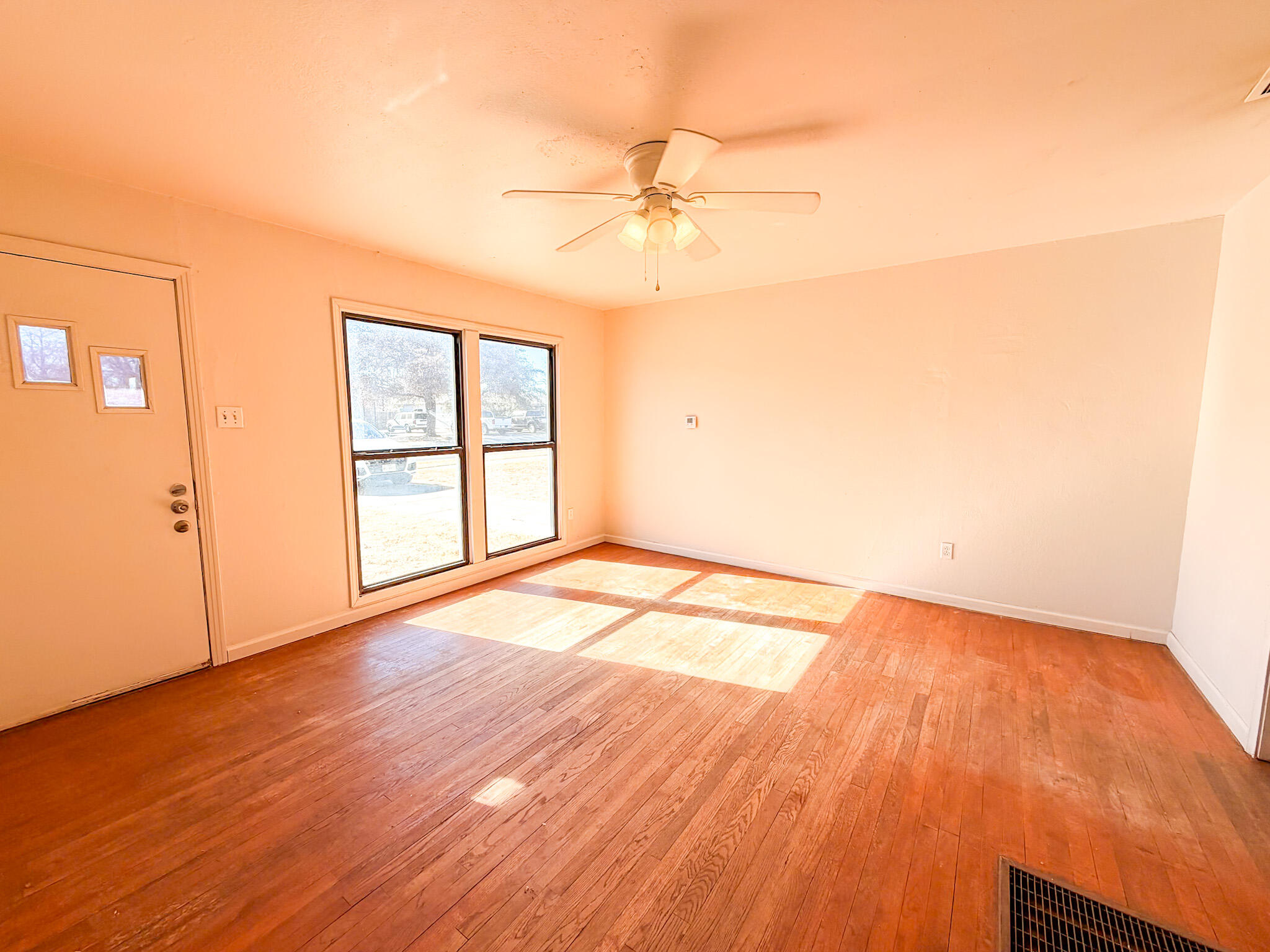 2616 38th Street Lubbock, TX 79413 - Photo 11 of 12 an empty room with wooden floor fan and windows