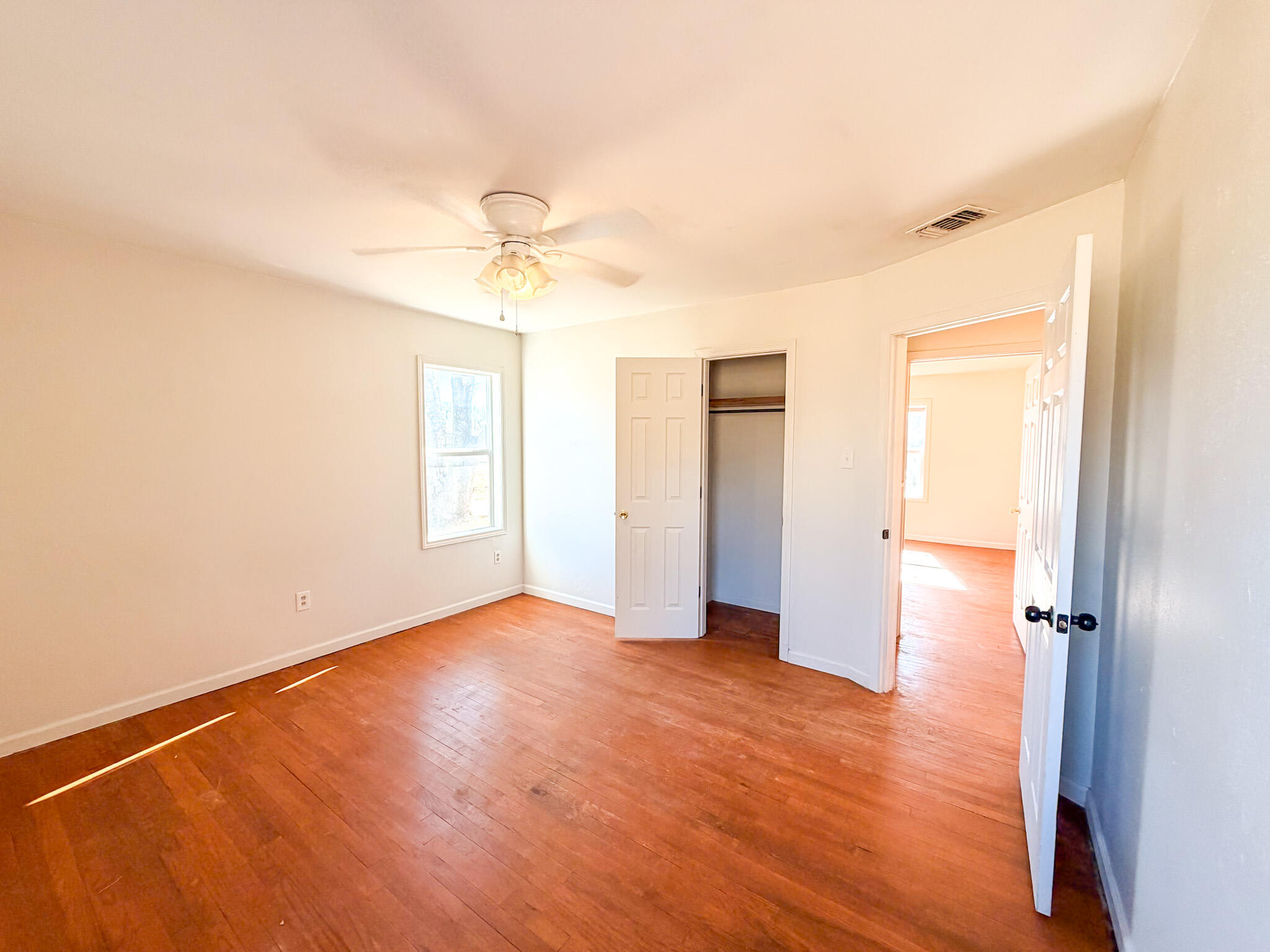 2616 38th Street Lubbock, TX 79413 - Photo 6 of 12 an empty room with wooden floor ceiling fan and windows
