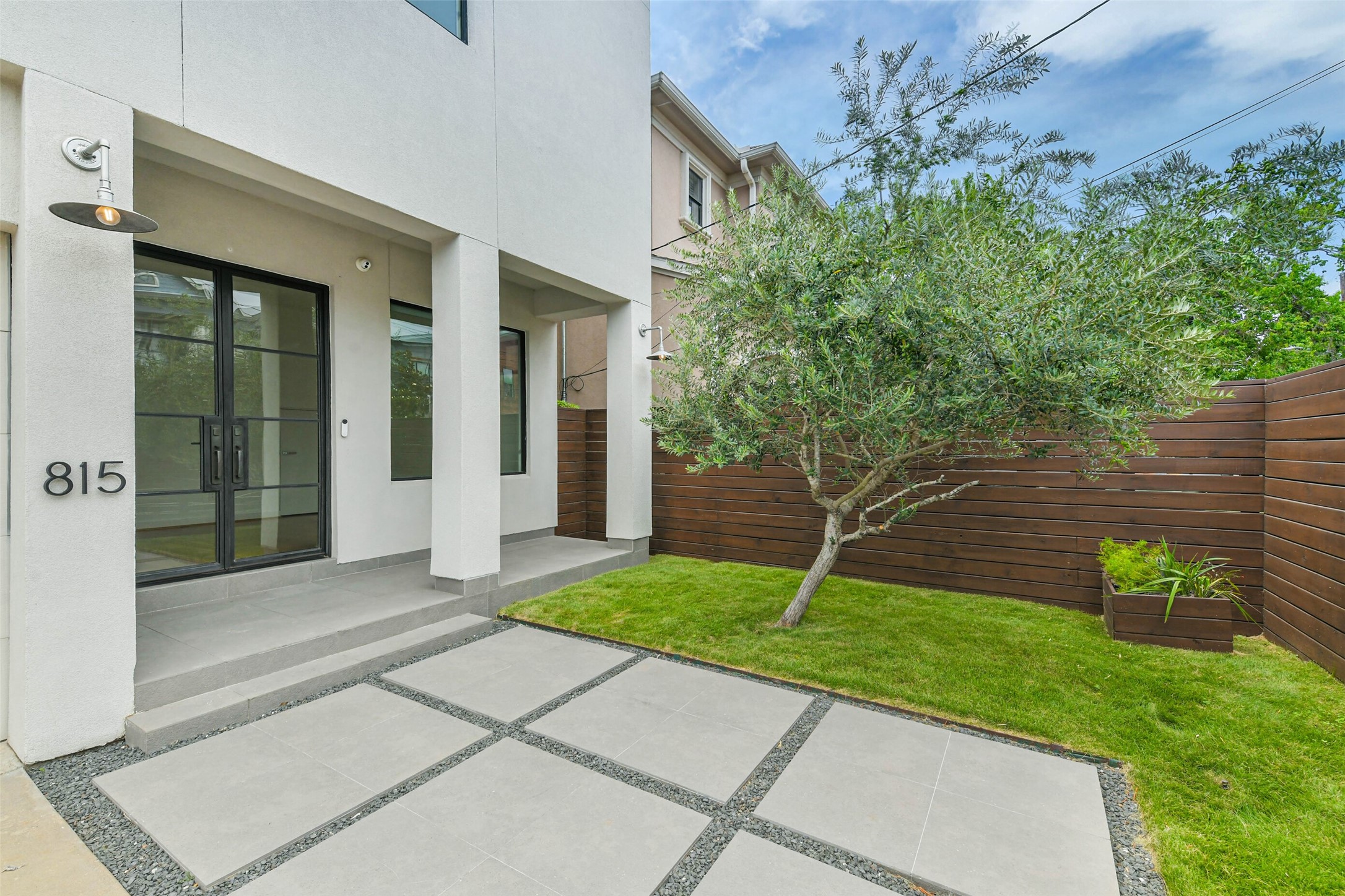 815 Alexander Street Houston, TX 77007 - Photo 3 of 49 Inviting covered front entrance welcomes you through a private, professionally landscaped courtyard featuring a mature olive tree, adding timeless beauty and charm.