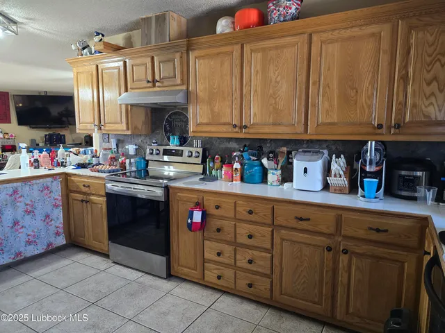 a kitchen with granite countertop a sink dishwasher stove and cabinets