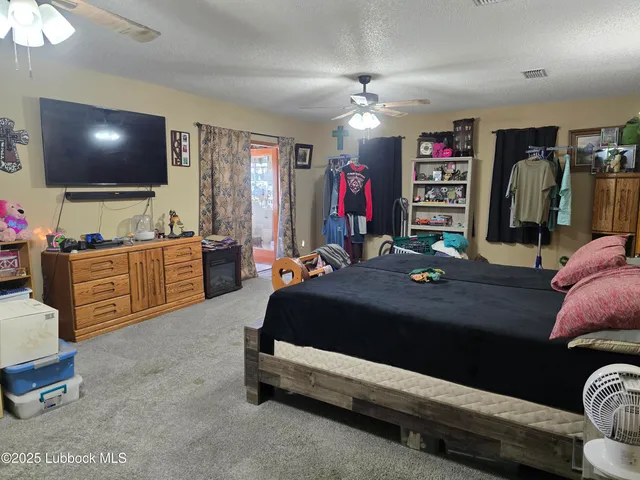 a bedroom with a bed gym equipment and view of living room