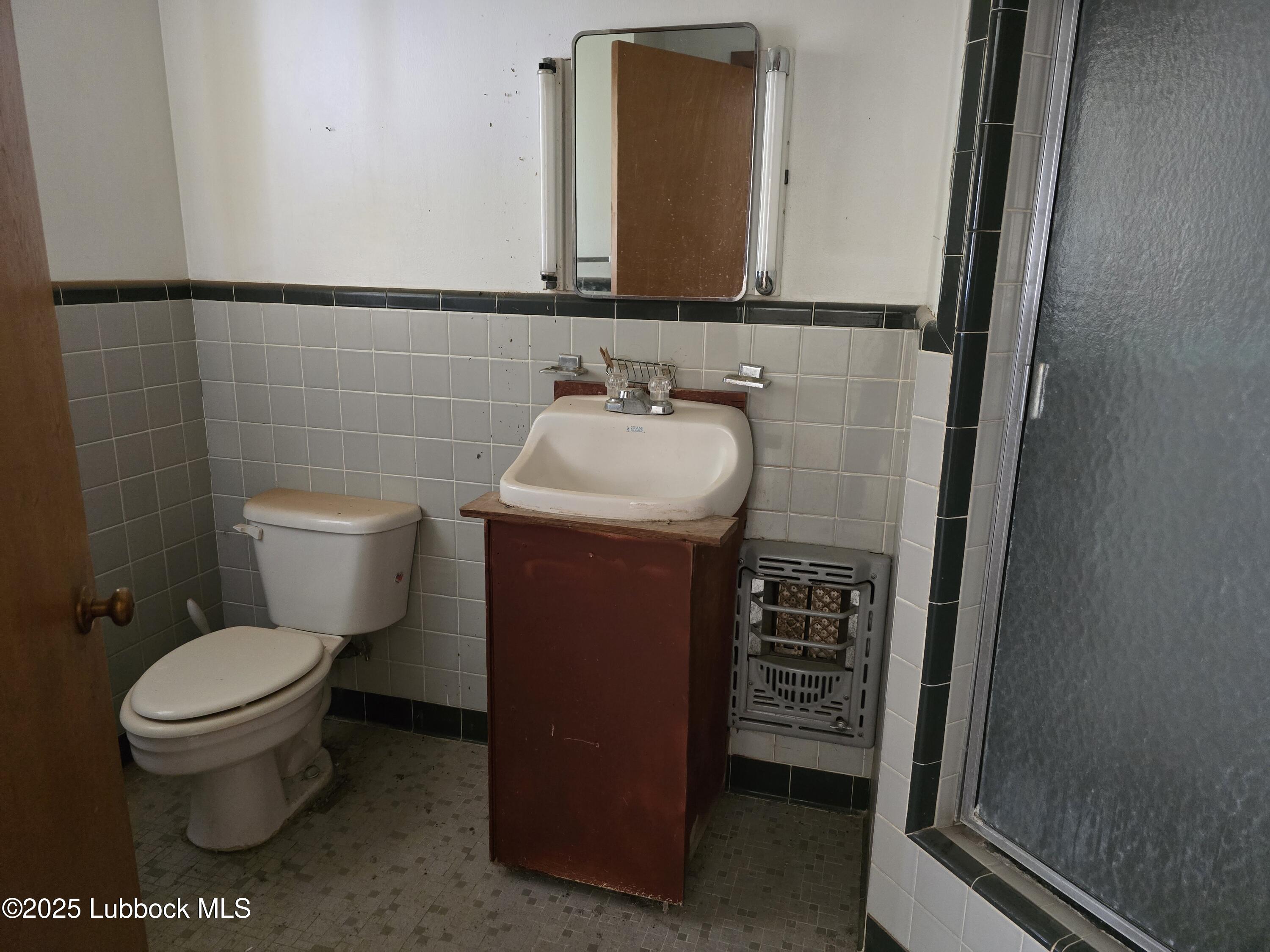 390 County Road Kress, TX 79052 - Photo 54 of 58 a bathroom with a toilet sink and mirror
