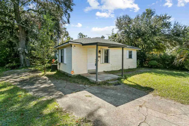 a white house that has a tree in front of it