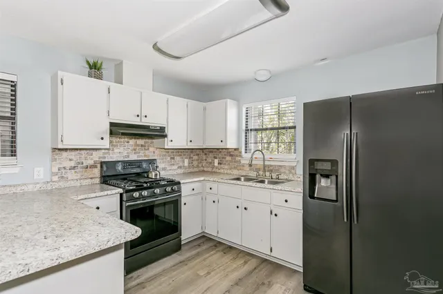 a kitchen with stainless steel appliances granite countertop a refrigerator stove and sink