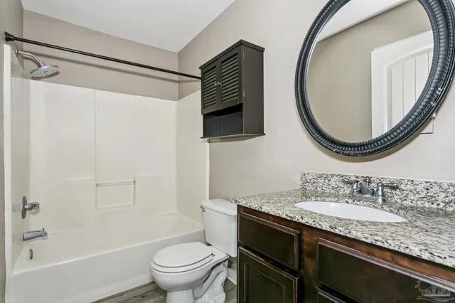 a bathroom with a granite countertop sink toilet and shower