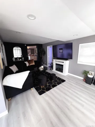 a living room with furniture a flat screen tv and a fireplace