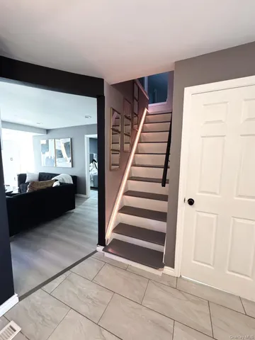 a view of a livingroom with wooden floor and stairs