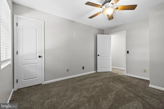 an empty room with closet and a chandelier fan