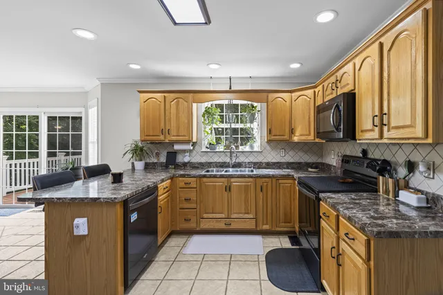 a kitchen with stainless steel appliances granite countertop a sink stove and cabinets