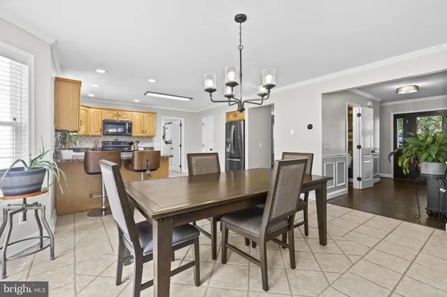 a view of a dining room and livingroom with furniture wooden floor a chandelier
