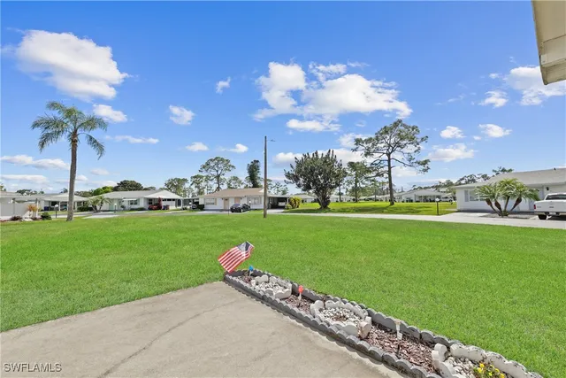 a car parked in front of a house with a big yard