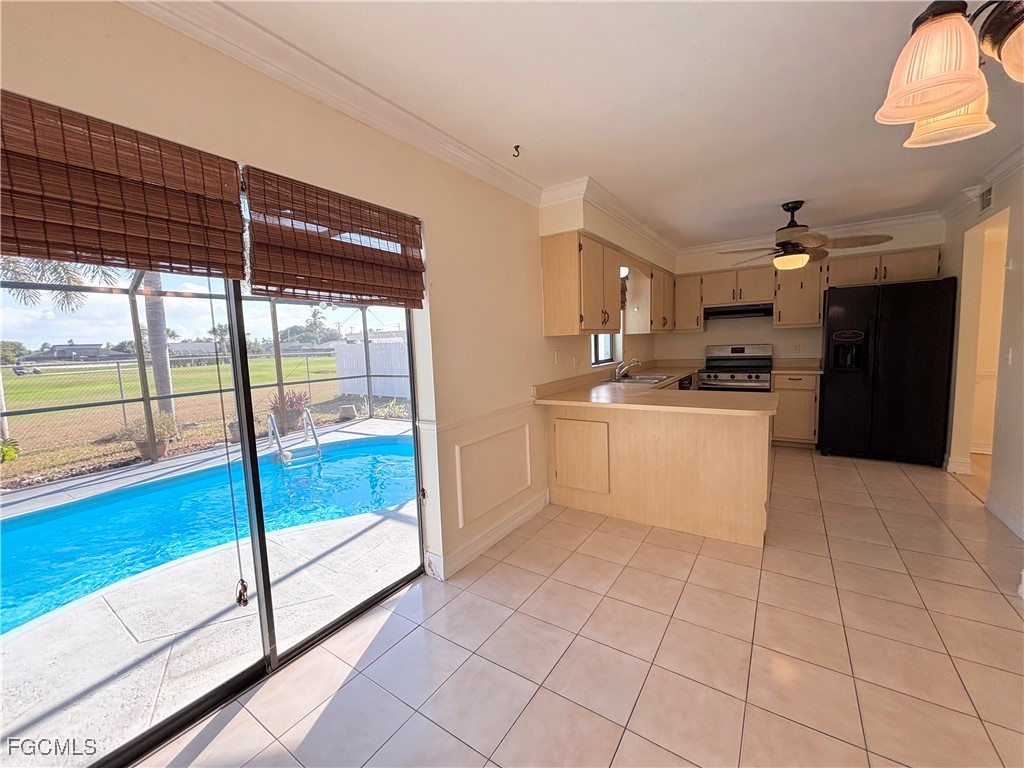 7280 Pebble Beach Road Fort Myers, FL 33967 - Photo 4 of 15 a large kitchen with a stove a refrigerator and white cabinets with wooden floor
