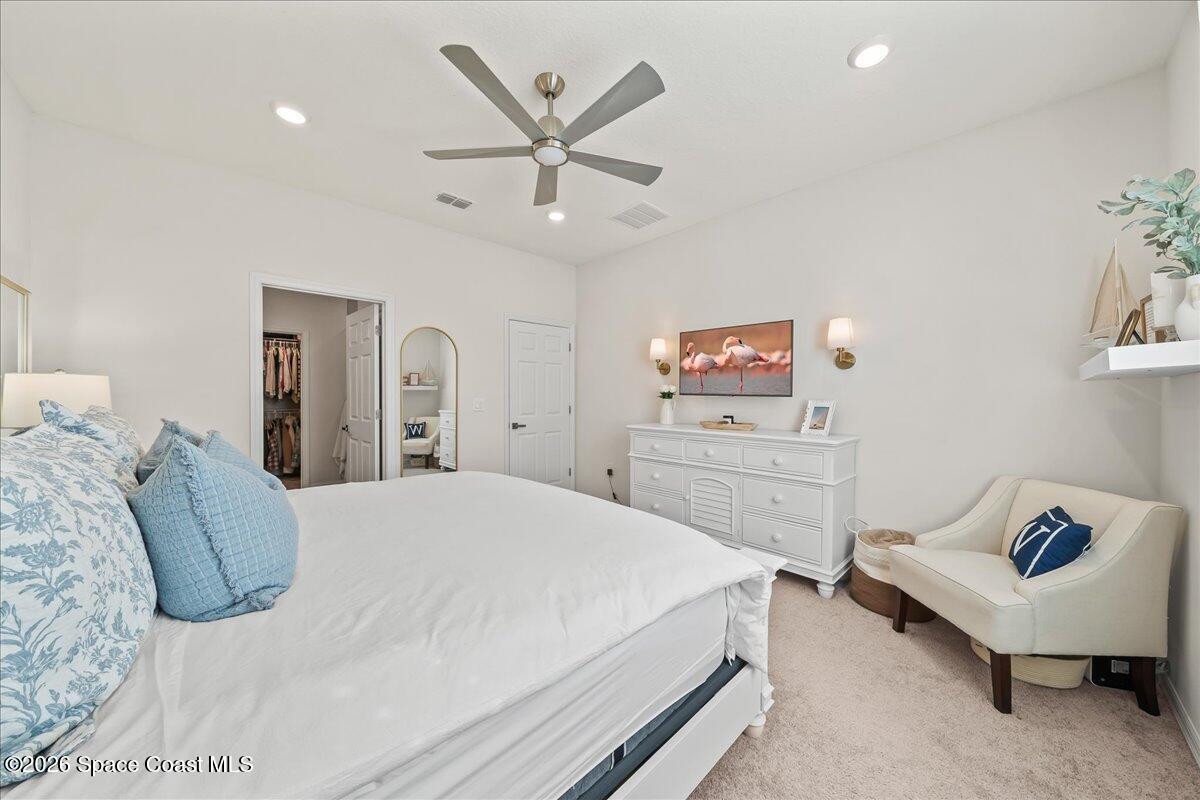 881 Covington Court Rockledge, FL 32955 - Photo 18 of 30 a bedroom with a large bed and a chandelier