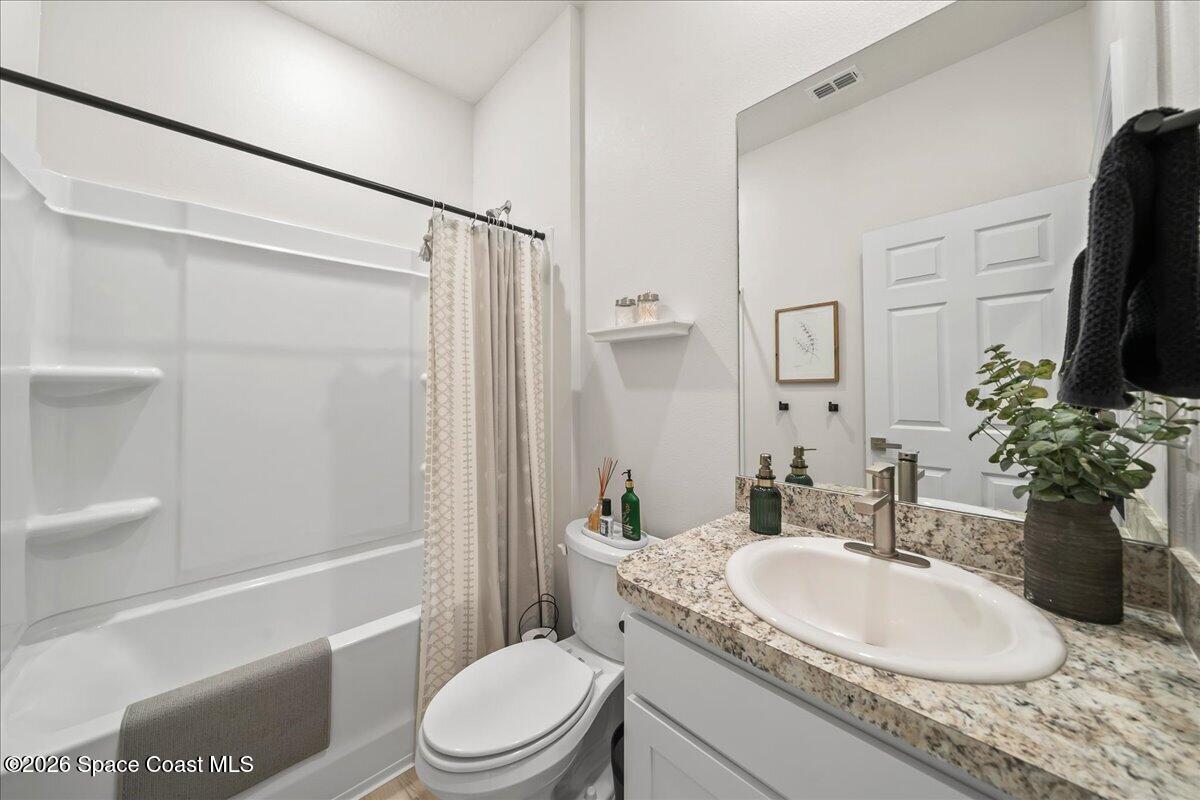 881 Covington Court Rockledge, FL 32955 - Photo 22 of 30 a bathroom with a granite countertop sink toilet and shower