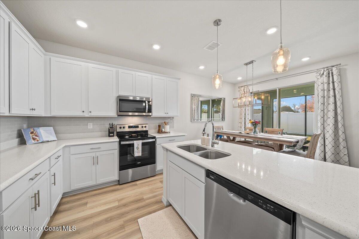 881 Covington Court Rockledge, FL 32955 - Photo 8 of 30 a kitchen with stainless steel appliances granite countertop a sink a stove and a refrigerator