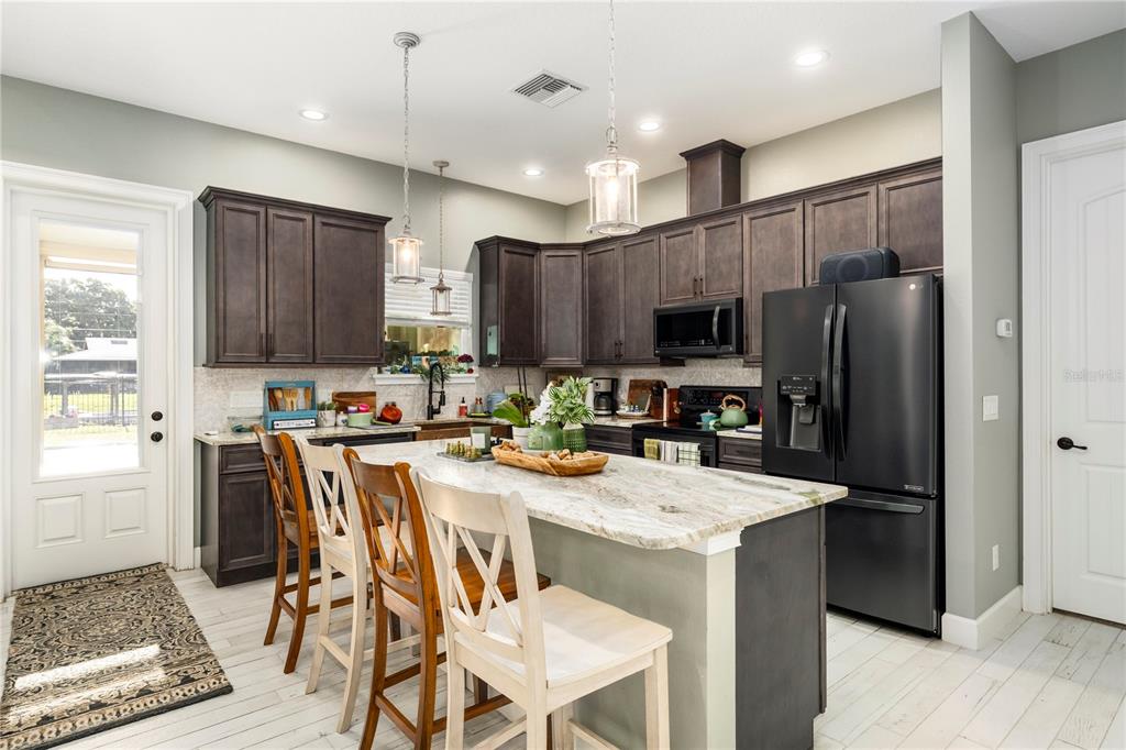 35638 Calla Court Leesburg, FL 34788 - Photo 11 of 44 a kitchen with a refrigerator a stove a sink and a microwave