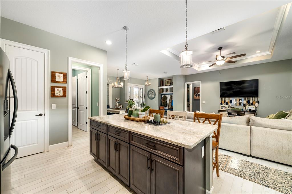 35638 Calla Court Leesburg, FL 34788 - Photo 12 of 44 a kitchen with a stove a refrigerator and a flat screen tv