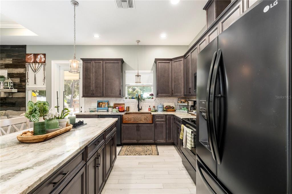 35638 Calla Court Leesburg, FL 34788 - Photo 14 of 44 a kitchen with kitchen island granite countertop a sink stove and refrigerator