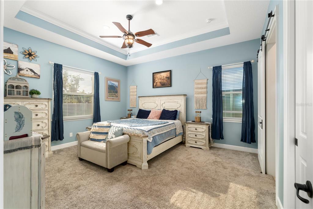 35638 Calla Court Leesburg, FL 34788 - Photo 19 of 44 a spacious bedroom with a bed and a couch