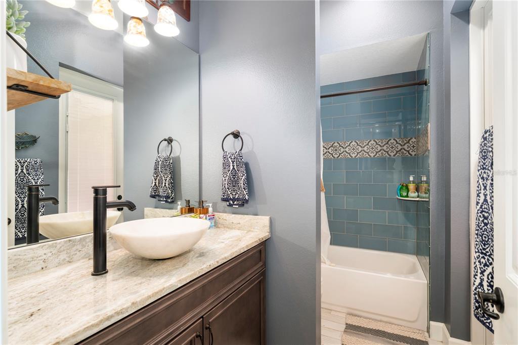 35638 Calla Court Leesburg, FL 34788 - Photo 36 of 44 a bathroom with a granite countertop sink a mirror and shower