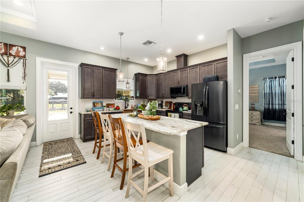 35638 Calla Court Leesburg, FL 34788 - Photo 10 of 44 a view of kitchen with refrigerator stove microwave and cabinets