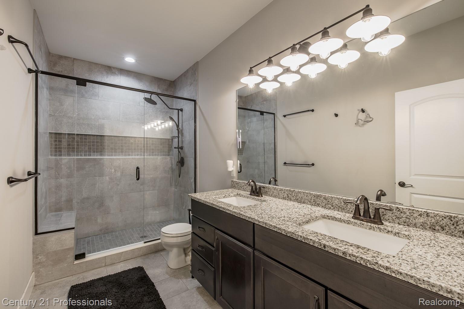 4914 TORATOLA Lane Howell, MI 48843 - Photo 24 of 39 Bathroom featuring double vanity, a shower stall, light tile patterned floors, and recessed lighting