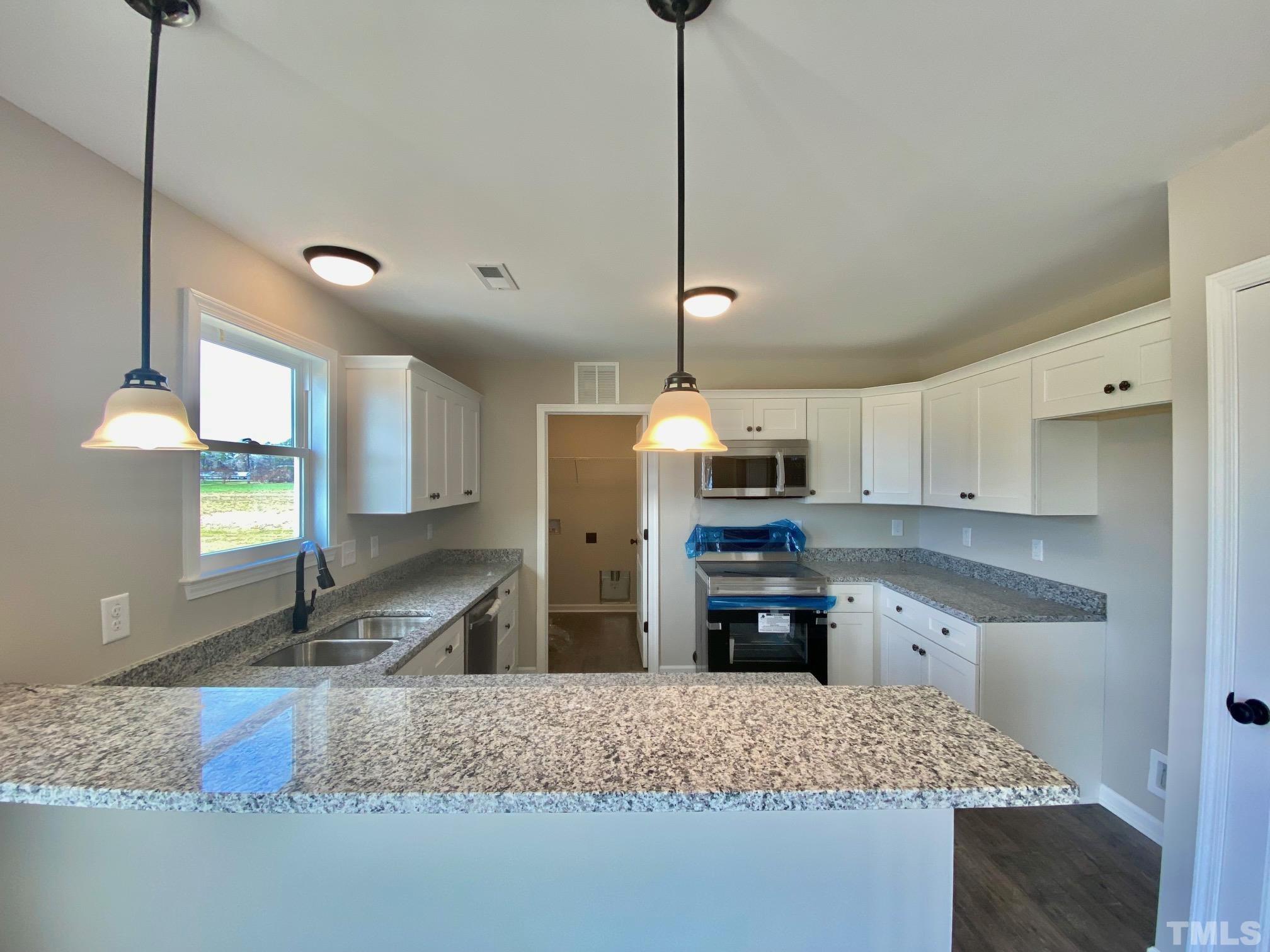 136 Mamie Road Benson, NC 27504 - Photo 13 of 32 a kitchen with stainless steel appliances granite countertop a sink stove and refrigerator