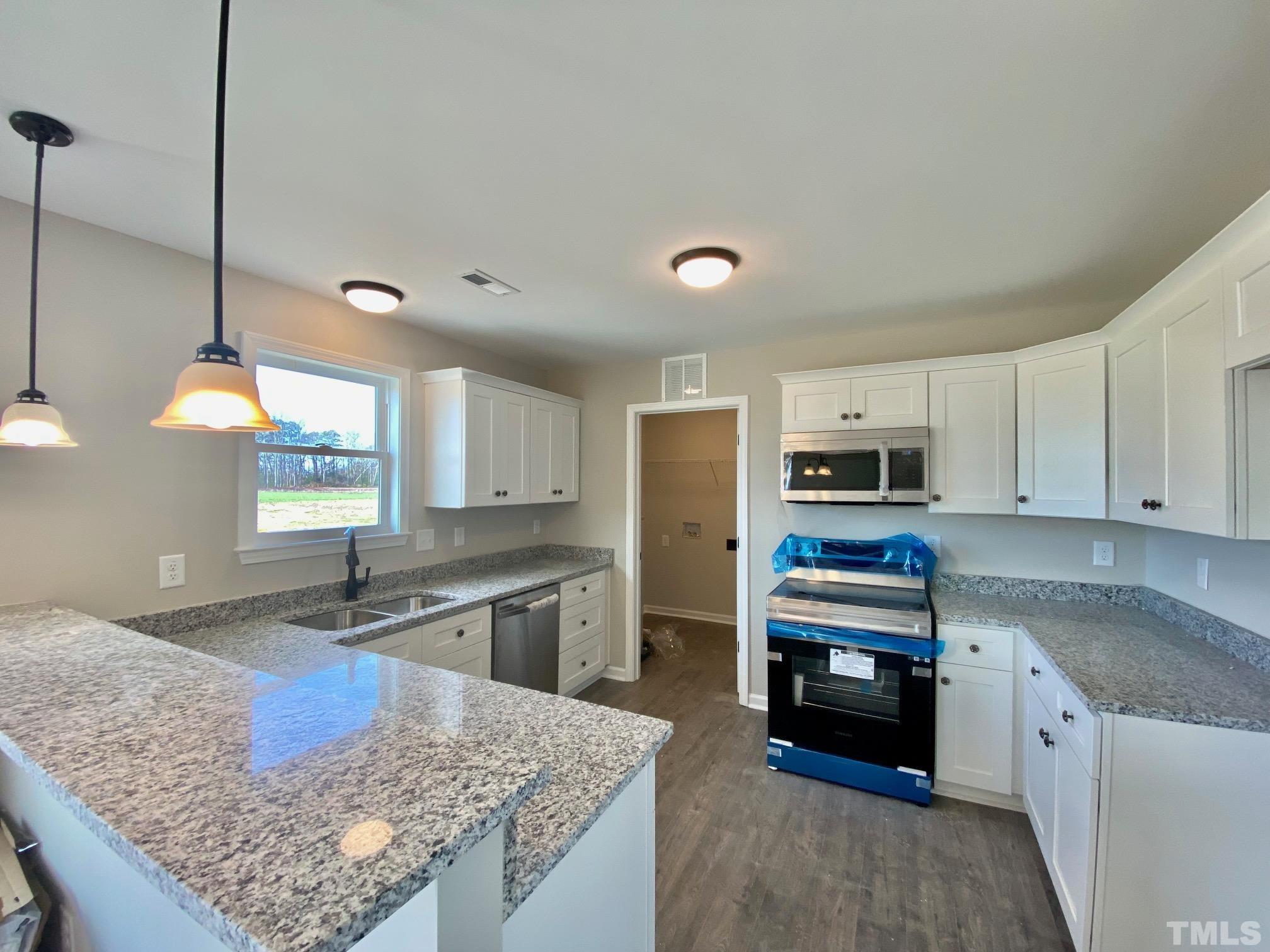 136 Mamie Road Benson, NC 27504 - Photo 14 of 32 a kitchen with stainless steel appliances granite countertop a sink stove and refrigerator